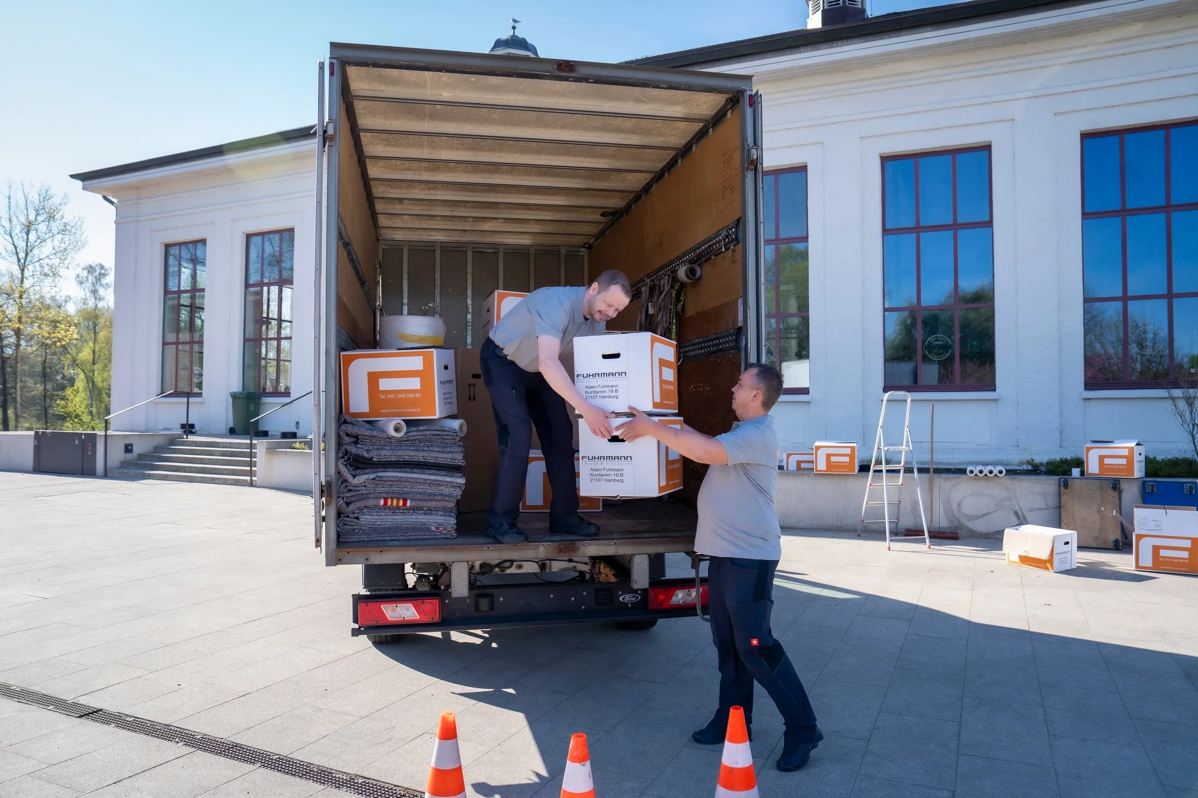 Fuhrmann-Team bei der Beladung – Übergabe einer Umzugsbox am LKW