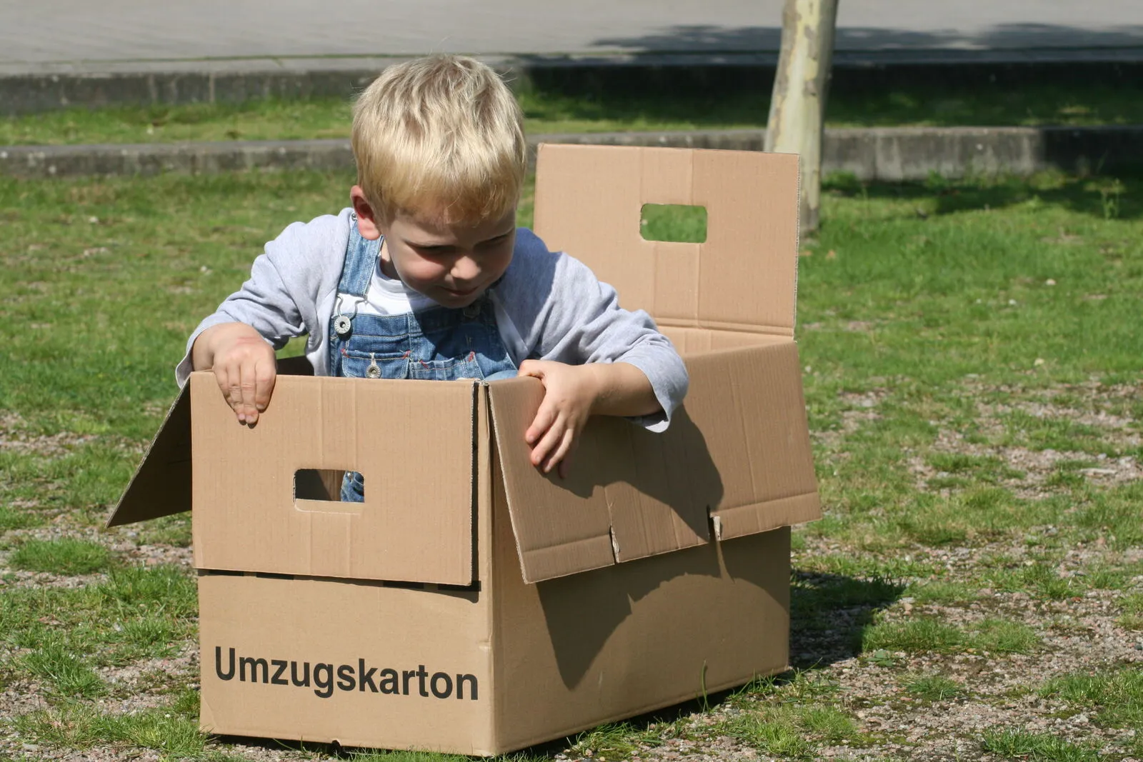 Kind spielt zwischen Umzugskartons -- Familienumzüge mit Fuhrmann