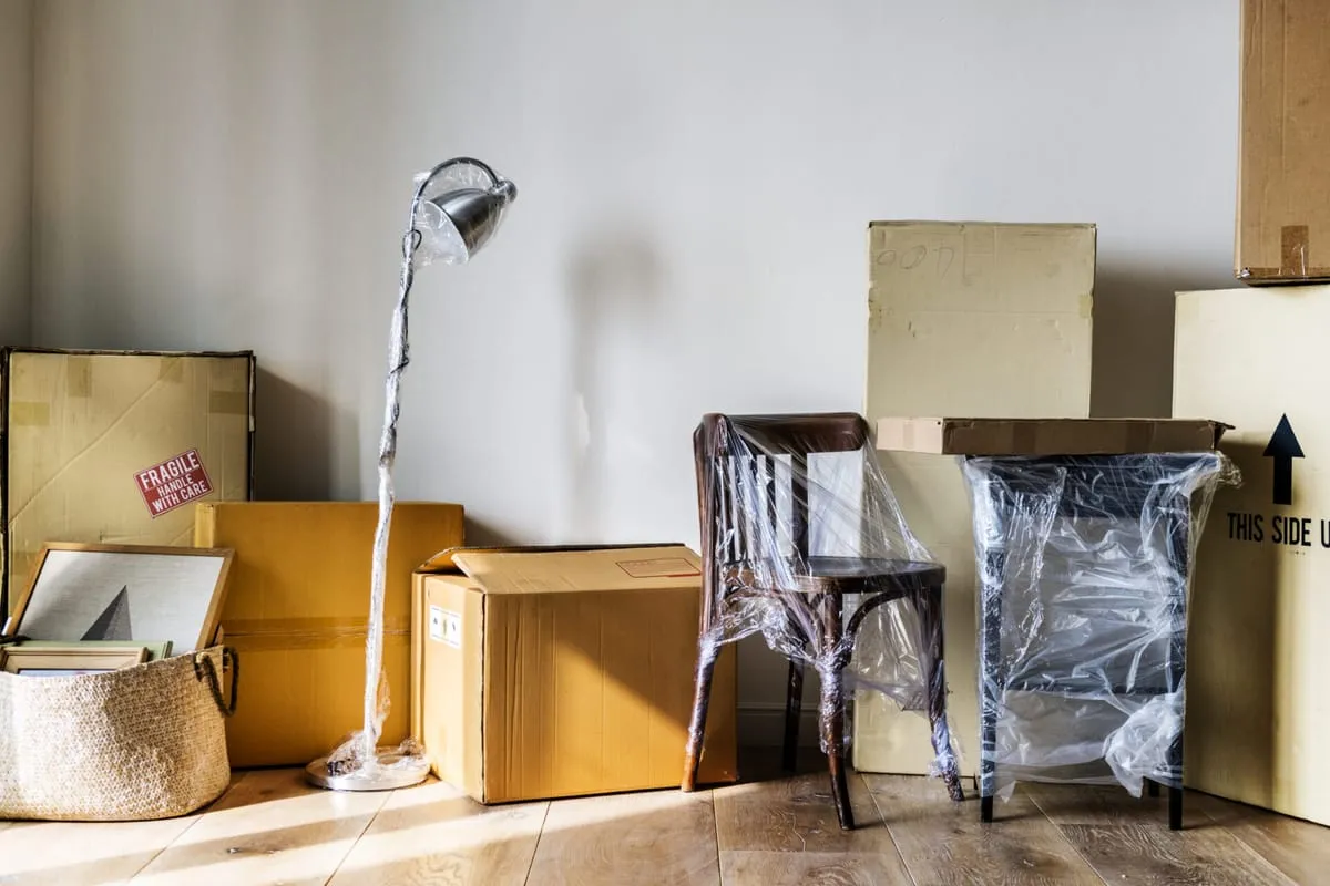 Verpackte Möbel und Umzugskartons – bereit für die erste eigene Wohnung