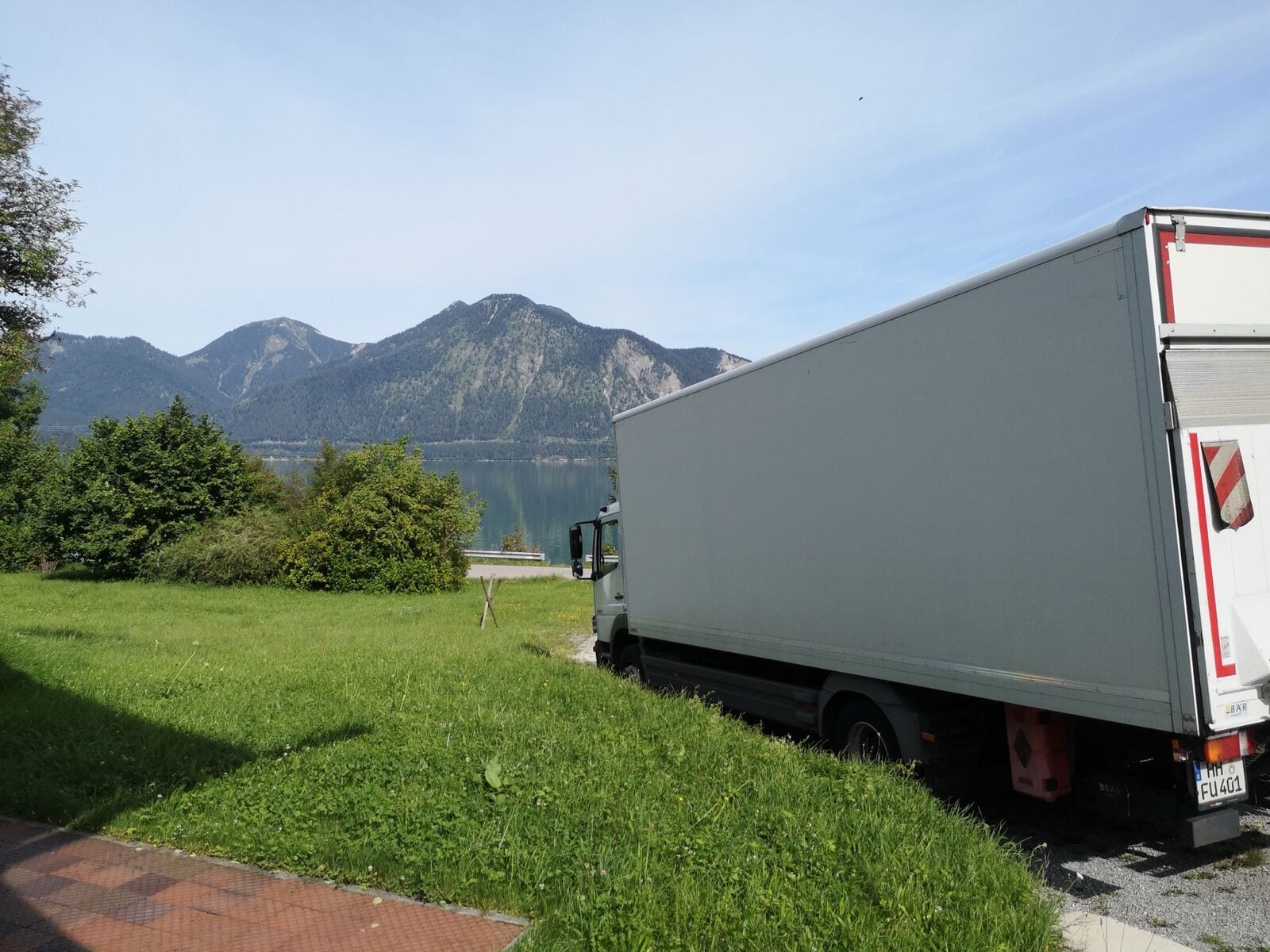 Fuhrmann LKW vor Alpen-Panorama mit Bergsee